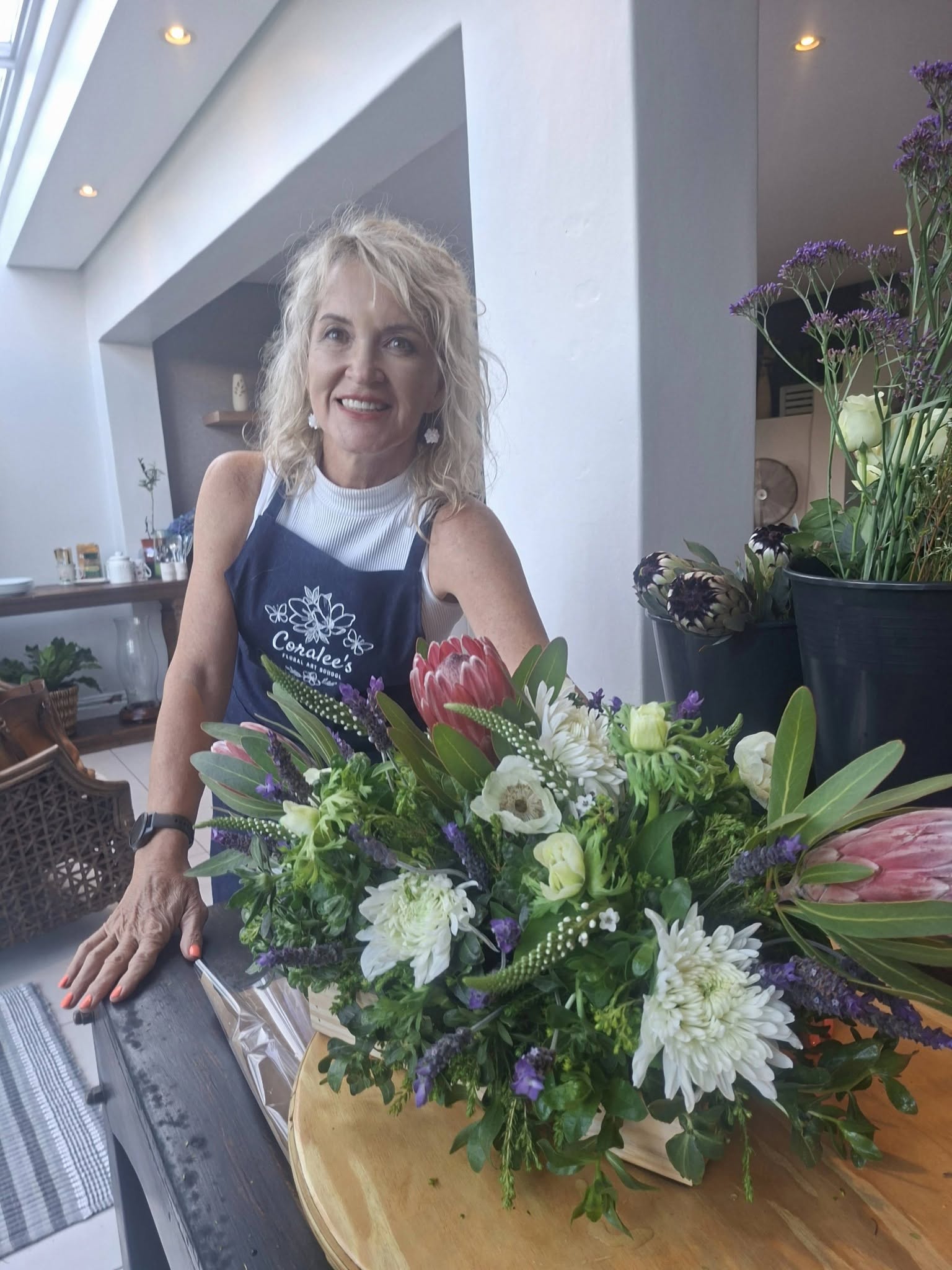 Judith Fick, founder of Jude's Blooms, smiling with a creative floral bouquet in Pongola, South Africa