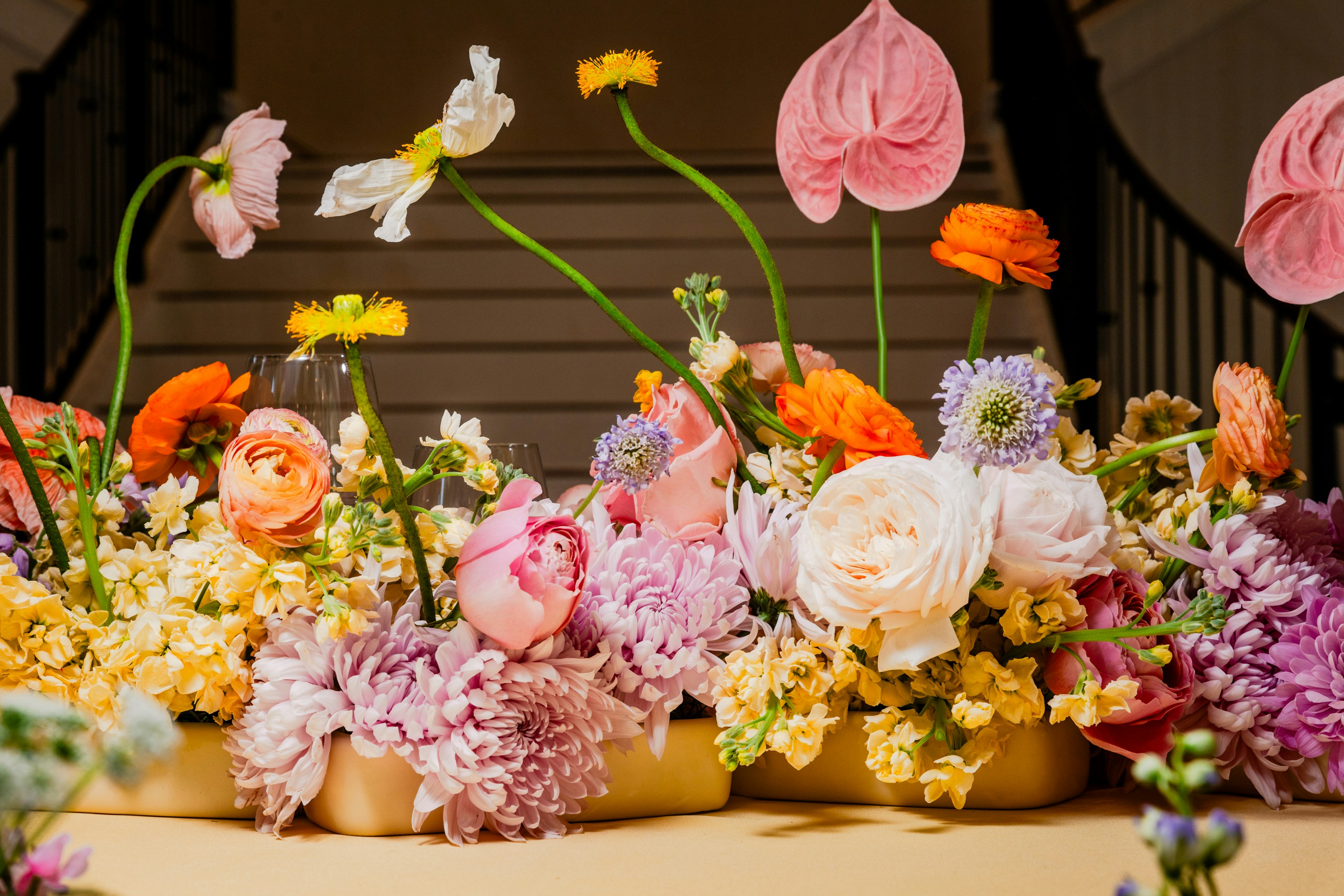 Vibrant mixed floral centrepiece with bold seasonal blooms for an event table